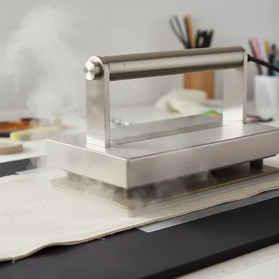 Steam ironing press with fabric and interfacing being fused for a professional sewing project.